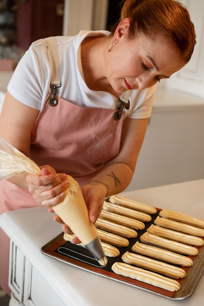 Photo female confectioner baking with dough in a pastry shop