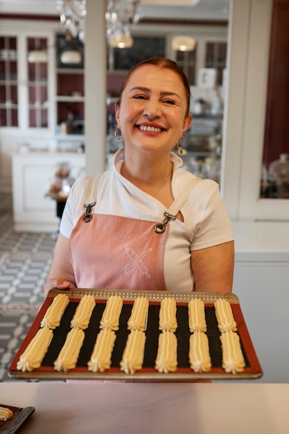 Photo female confectioner baking with dough in a pastry shop