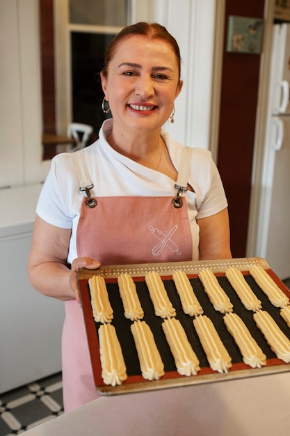 Photo female confectioner baking with dough in a pastry shop