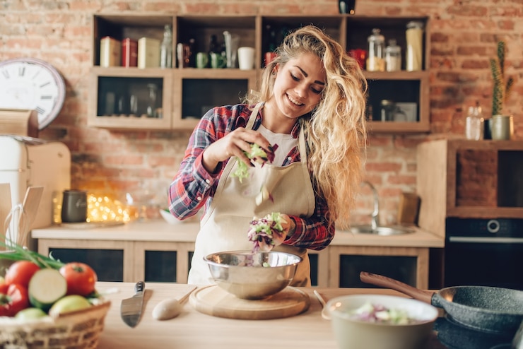 Photo female cook in apron prepares fresh salad