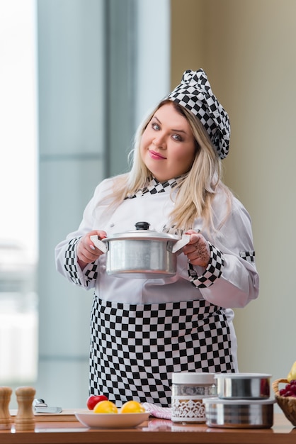 Female cook preparing soup in brightly lit kitchen