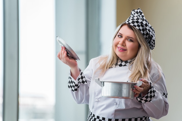 Female cook preparing soup in brightly lit kitchen