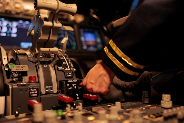 Female copilot pushing dashboard buttons in plane cockpit,\
preparing to takeoff with engine lever or handle. airliner using\
control panel command and windscreen navigation radar. close\
up.