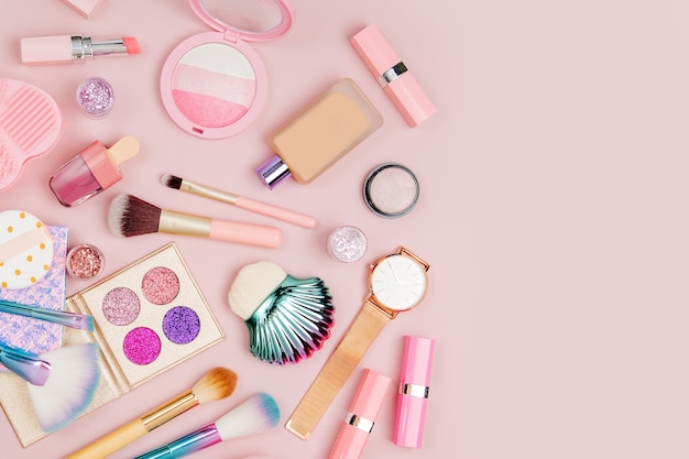 female cosmetics collage with lipstick brush and other accessories on pink background