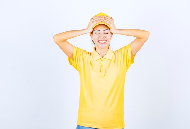 Female courier in yellow uniform looks surprized and terrified. 