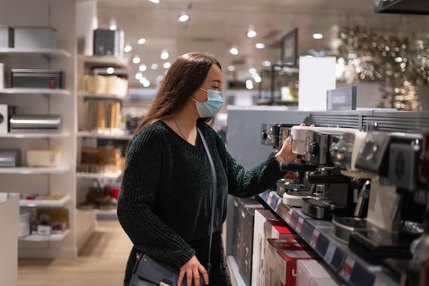 コーヒーメーカーを選ぶ女性客