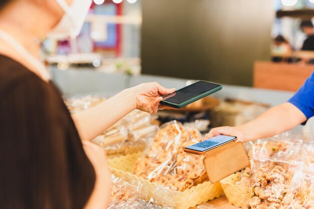 Female customer in protective mask make contactless mobile payment