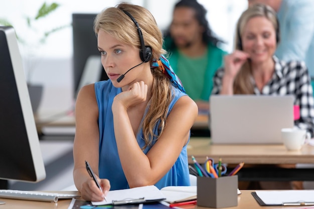 Female customer service executive working at desk in a modern office