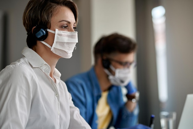 Female customer service representative working in a call center during coronavirus pandemic