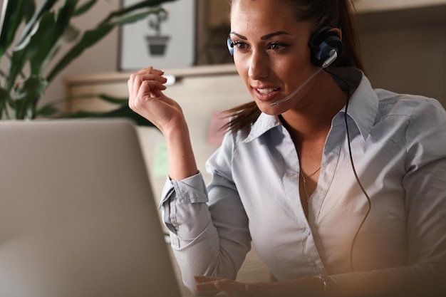 Female customer service representative working on a computer while talking to a customer