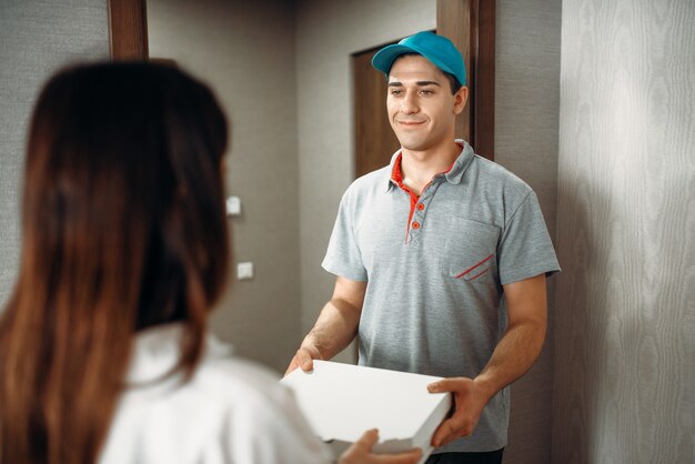 Female customer signs order to pizza delivery boy