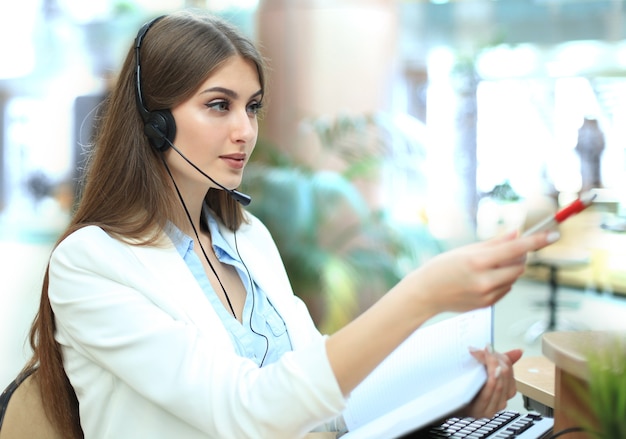 Foto operatore dell'assistenza clienti femminile con auricolare e sorridente