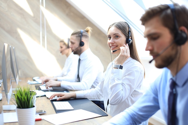 Female customer support operator with headset and smiling.