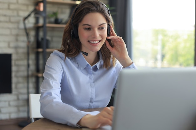 Female customer support operator with headset and smiling.