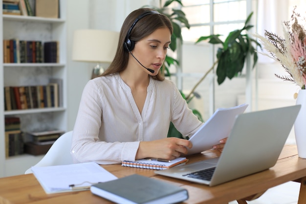 Female customer support operator with headset and smiling.