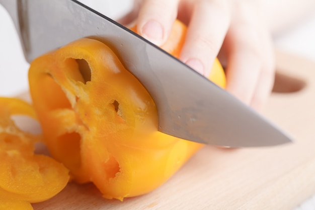 Female cutting sweet bulgarian pepper