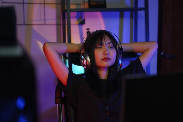 female cyber hacker gamer holds hands behind head to resting after watching and hacking video games