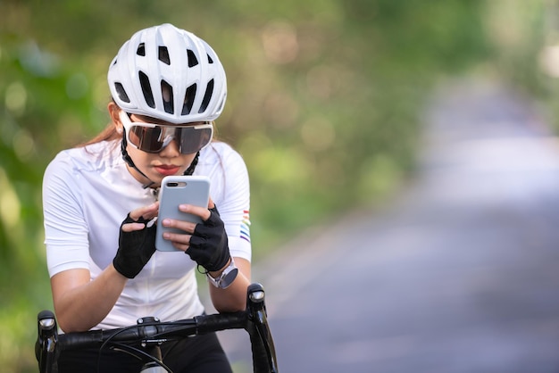 運動のための自転車に乗っている間にスマートフォンで女性サイクリストサイクリングselfie女性社会グループ