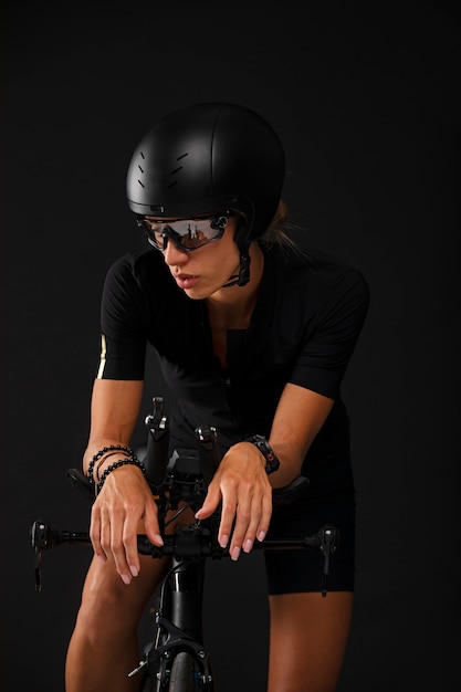 Female cyclist posing with bicycle and helmet