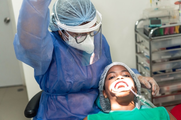 A female dentist checking her teeth at a dental exam.