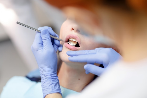 Female dentist checking patient girl teeth