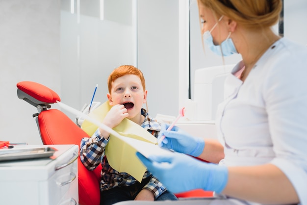 Женский стоматолог и ребенок в кабинете стоматолога