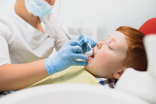 Женский стоматолог и ребенок в кабинете стоматолога