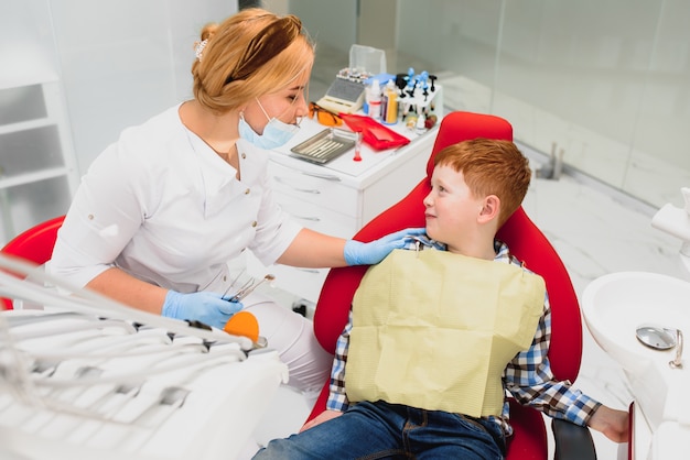 Dentista femminile e bambino in uno studio dentistico