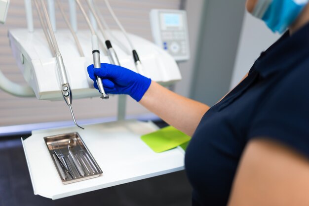 Foto il medico dentista femminile prende un trapano