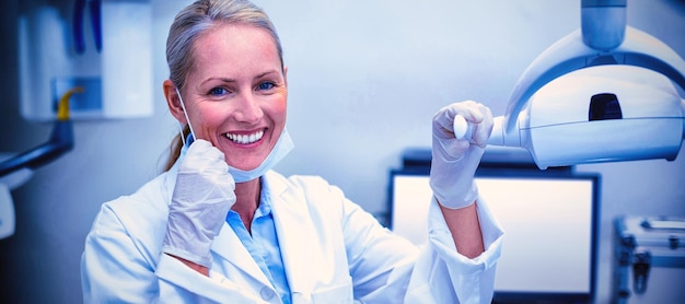 Photo female dentist holding dental lights