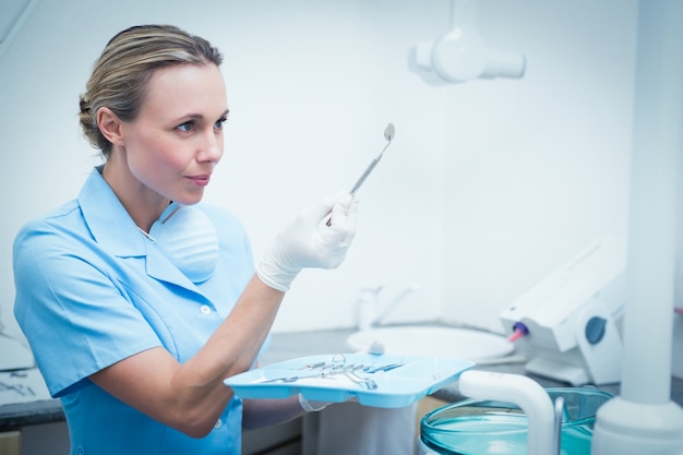 Foto dentista femminile che tiene strumento dentario