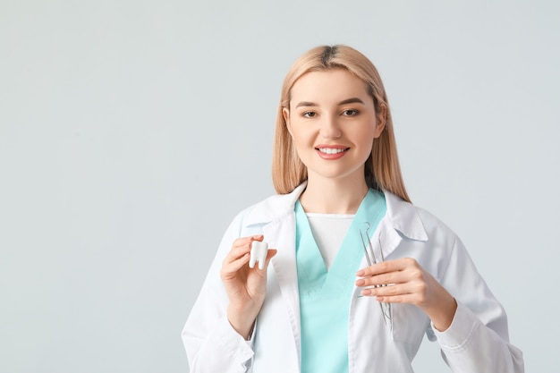 Female dentist on light surface