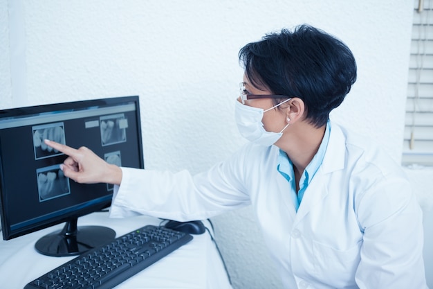 Female dentist looking at x-ray on computer