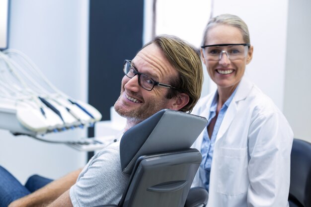 Female dentist and male patient smiling