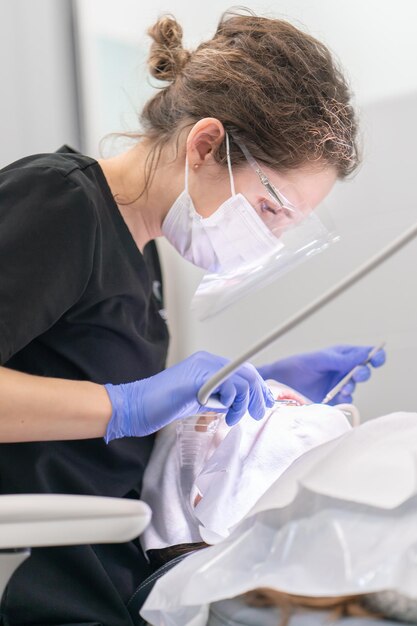 Photo a female dentist provides emergency dental care to a patient at a dental clinic