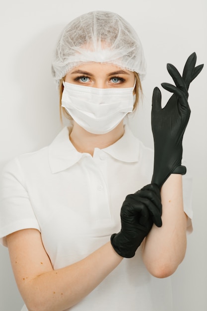 Female dentist puts on rubber or latex gloves