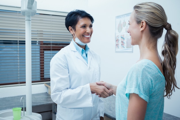 Dentista femminile che agita le mani con la donna