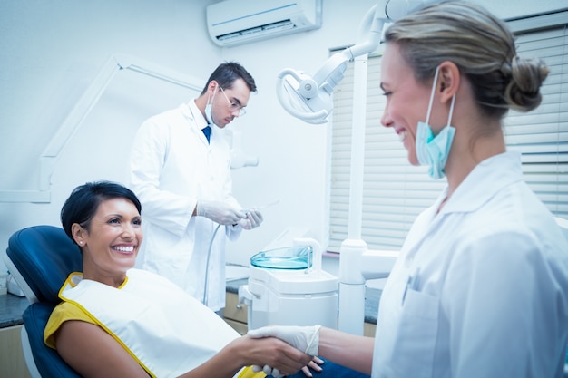 Dentista femminile che agita le mani con la donna