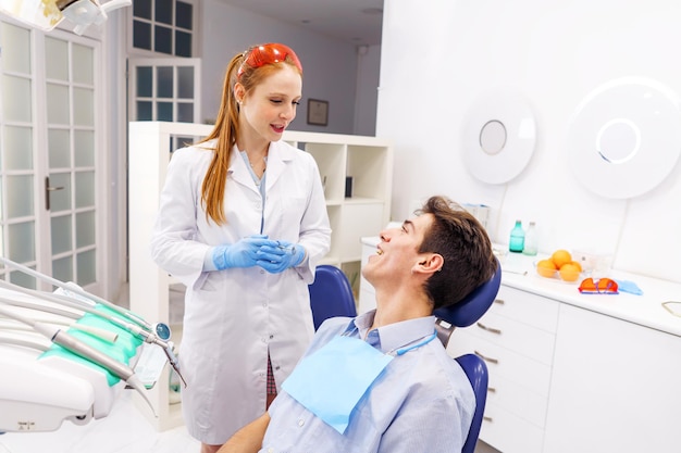 Dentista femminile che parla con un paziente maschio