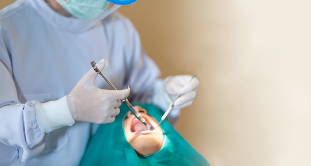 Female dentist standing in dentist office work with light-curing seal