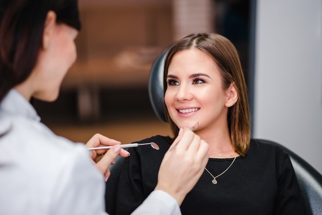 Dentista femminile con paziente femminile durante il controllo dentale.