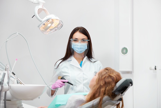 Female dentist working at her dental office examining her patient