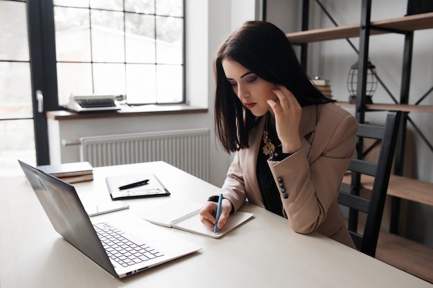 Female designer noting ideas on workplace