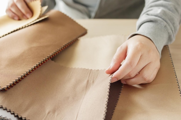 female designer with fabric color samples choosing textile for curtains