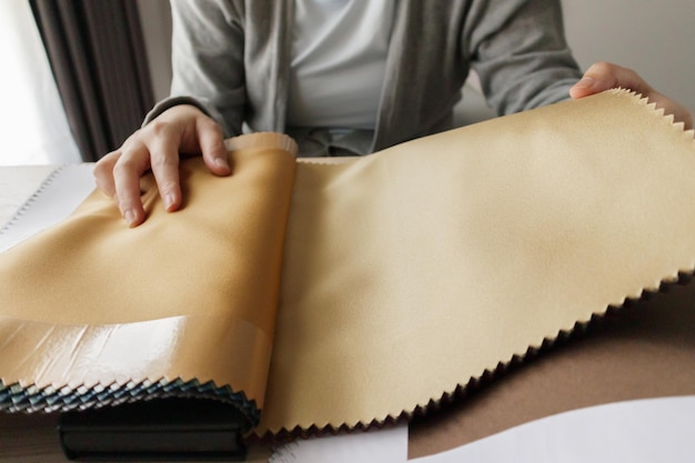 female designer with fabric color samples choosing textile for curtains