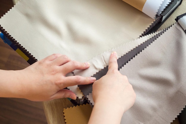 Female designer with fabric color samples choosing textile for curtains