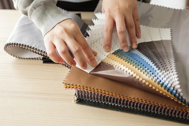 Female designer with fabric color samples choosing textile for curtains