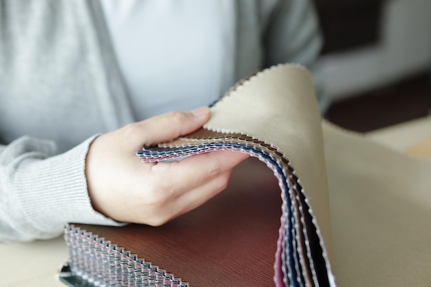 Female designer with fabric color samples choosing textile for curtains