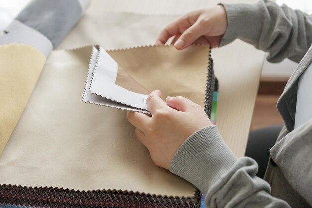 Female designer with fabric color samples choosing textile for curtains