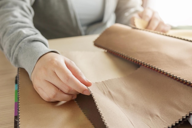 Female designer with fabric color samples choosing textile for curtains